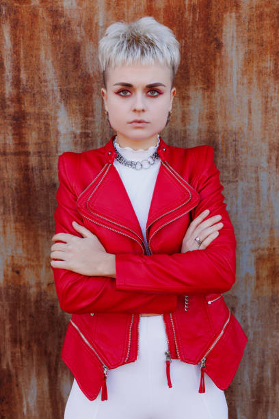 istock Confident modern woman in bright leather jacket looking at camera on textured rusty background 2182667794