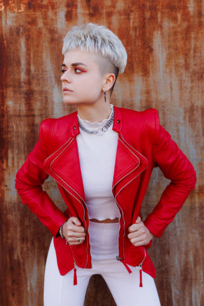 istock Modern woman in stylish red leather jacket posing on textured rusty background 2182667812