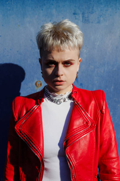 istock Stylish short haired woman in red leather jacket looking at camera on textured blue background 2182667953