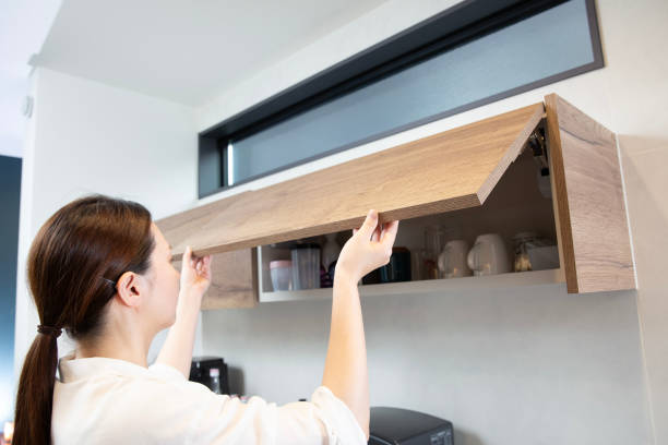 istock Kitchen storage: Woman opening door, upper storage rack 2182670048