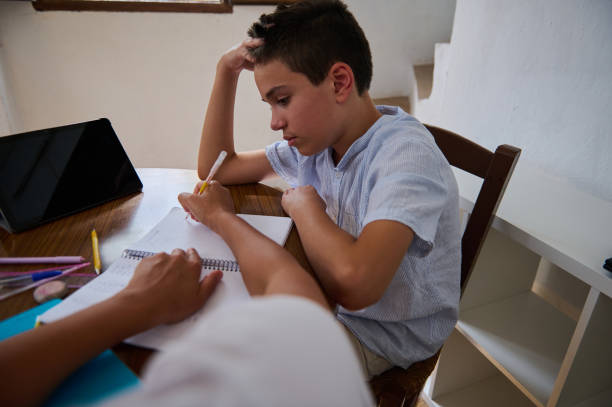 istock Young boy concentrating on his homework at home 2182673866
