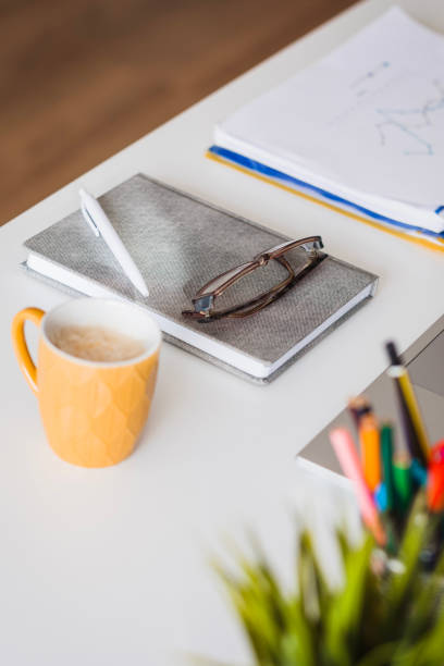 Planner, a pen and eyeglasses lying on an office desk