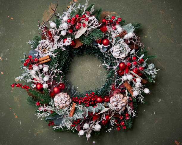 istock Christmas pine needle wreath with red decoration on blue background with bokeh 2182674996