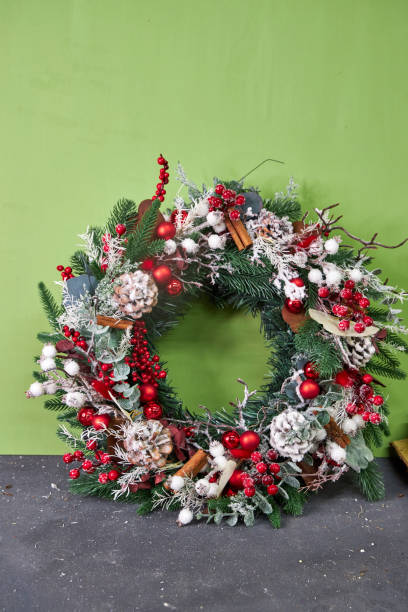istock Christmas pine needle wreath with red decoration on blue background with bokeh 2182675001