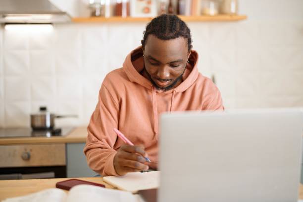 istock Close-up of a man doing his homework at home 2182677499