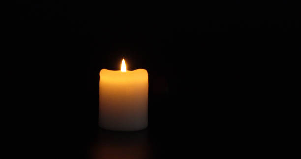 istock A burning insulated candle on a dark background. 2182679637