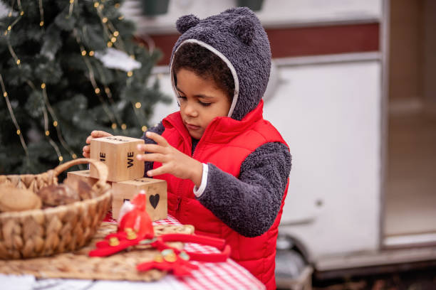 istock Child Stacking Wooden Blocks Outdoors During Holiday Season 2182683354