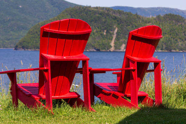 istock Peaceful Lakeside Scene with Red Adirondack Chairs 2182687195