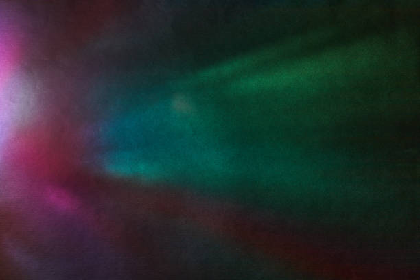 Soft Bright multicolored glare on dark rough textured cardboard. Soft rainbow light. Abstract colorful background.