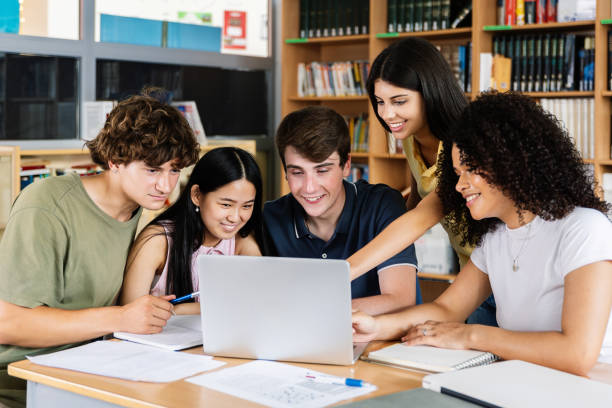 istock Diverse group of five high school students working together on laptop at library 2182688301