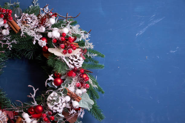 istock Christmas pine needle wreath with red decoration on blue background 2182688671