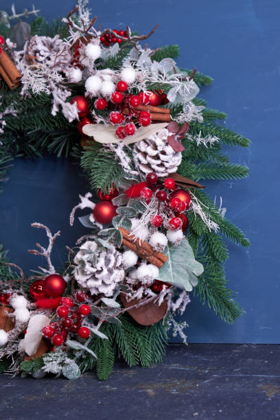 istock Christmas pine needle wreath with red decoration on blue background 2182689879