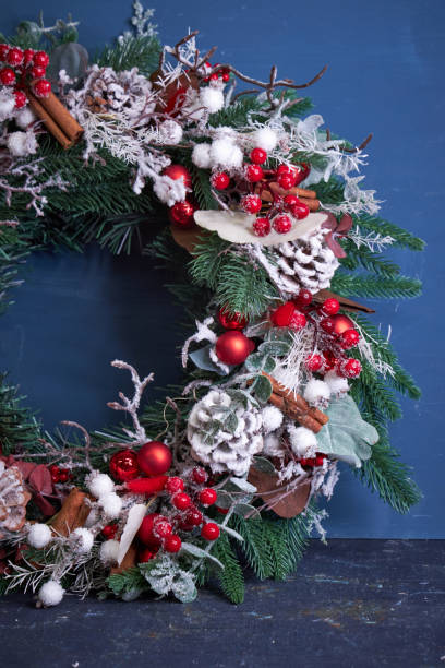 istock Christmas pine needle wreath with red decoration on blue background 2182690268