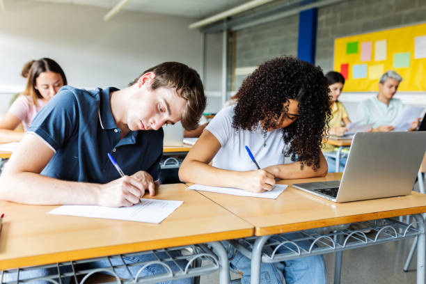 istock Diverse young students doing an exam at high school classroom. 2182690481