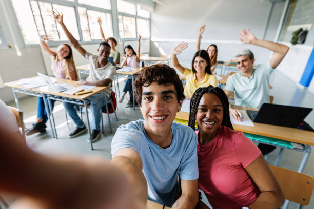 istock Joyful group of high school students taking selfie during lecture in classroom 2182690600