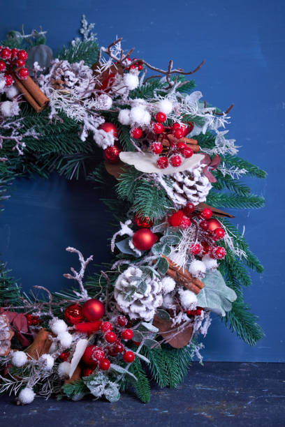 istock Christmas pine needle wreath with red decoration on blue background 2182690674