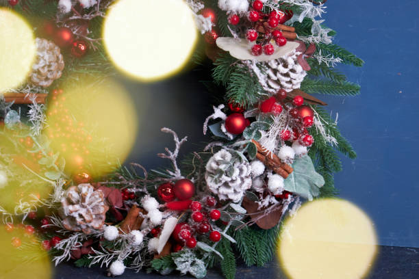 istock Christmas pine needle wreath with red decoration on blue background 2182691986