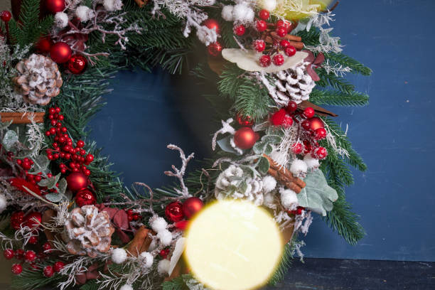 istock Christmas pine needle wreath with red decoration on blue background 2182692295