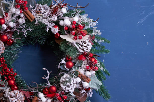 Christmas pine needle wreath with red decoration on blue background