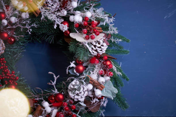 istock Christmas pine needle wreath with red decoration on blue background 2182693772