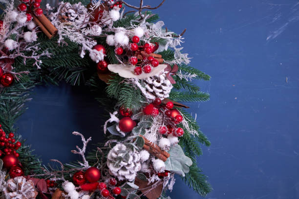 istock Christmas pine needle wreath with red decoration on blue background 2182694454