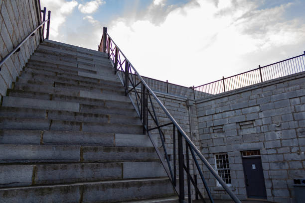 City stairs ascending between modern and traditional buildings under a clear blue sky