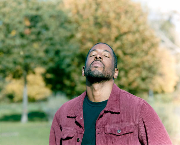 istock Young man in a park, breathing deeply, enjoying autumn air and sunlight 2182696159