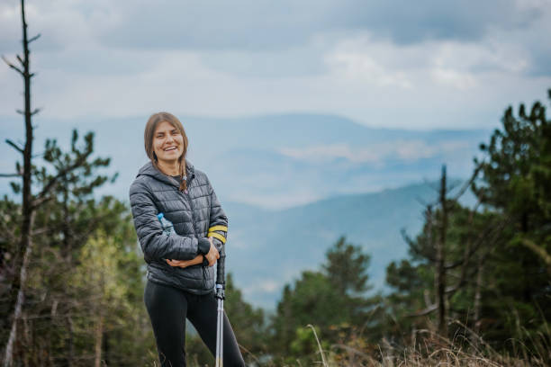 istock Mountaineer poses confidently against a breathtaking mountain backdrop with a smiling expression during a daytime hike in nature 2182698726