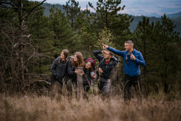 istock Group of outdoor explorers using a tablet for navigation in a lush forest during their hiking adventure 2182699692