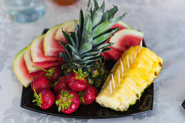 Close up of different types of fruit on a black plate