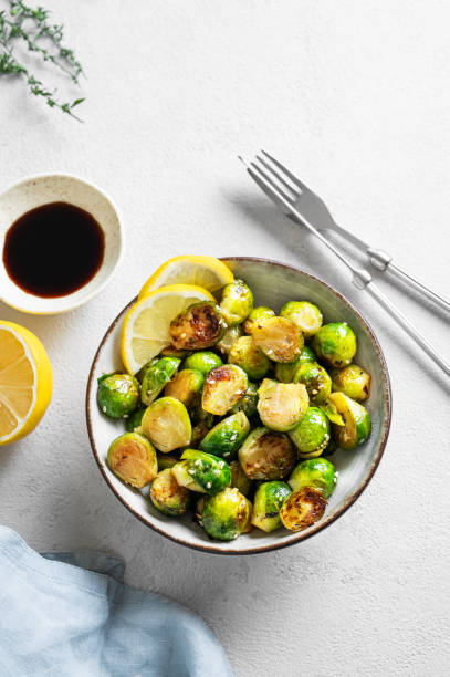 istock Fried brussels sprouts in a bowl with soy sauce, lemon and sesame on a light background with  herb and napkin. 2182701853
