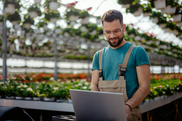 istock Florist Man in a Plant Nursery using Laptop 2182715365