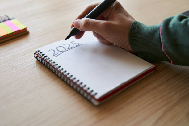 new year's resolutions. hand writing 2025 text in notebook - ふせん 目標 ストックフォトと画像