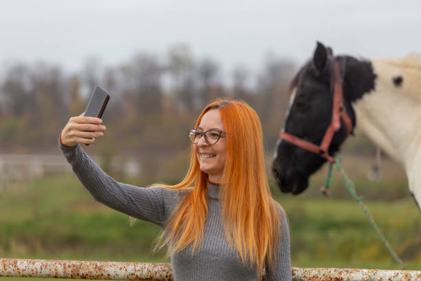 istock Woman taking a selfie outdoors with horse 2182715934