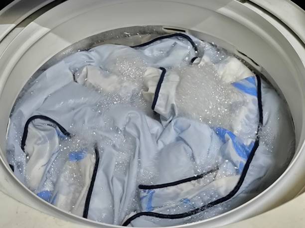 istock Washing blankets in a top-loading washing machine. Laundry and house keeping concept 2182718480