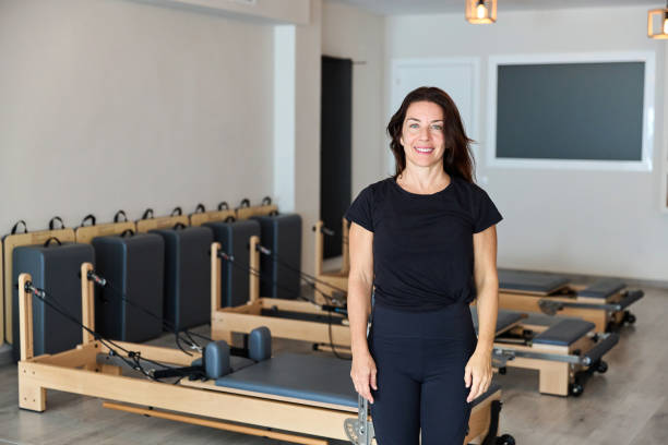 istock Pilates instructor is smiling in a gym full of reformers, ready to start a class 2182719590