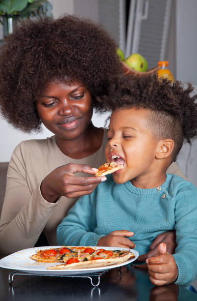 istock Mother and baby son having pizza at home 2182721845