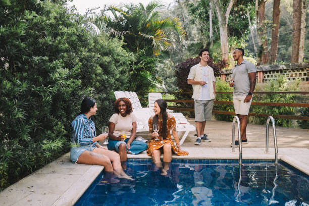 istock Group of young adults having conversations in the pool area 2182741048