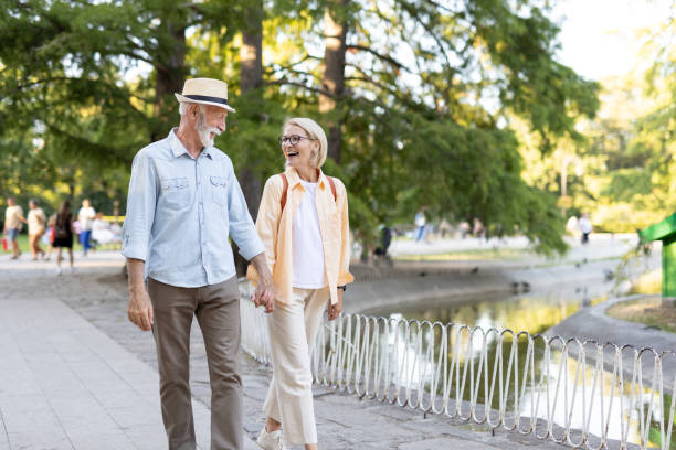 istock Smiling senior pair taking a leisurely walk in the park 2182743344
