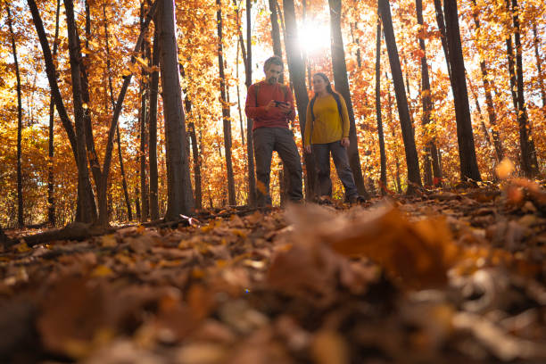 istock Mature Couple Hiking in Autumn Woods, Using GPS on Trail 2182744920