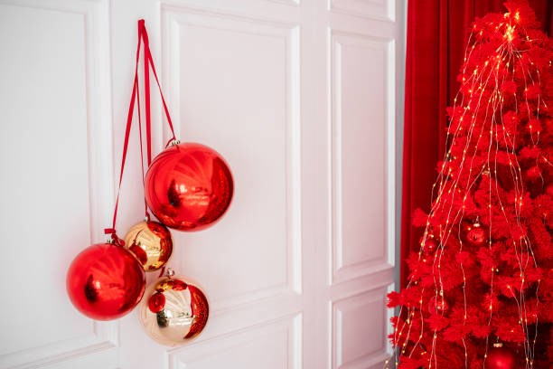 istock Decorative red and gold Christmas ornaments hanging beside a festive tree 2182745051