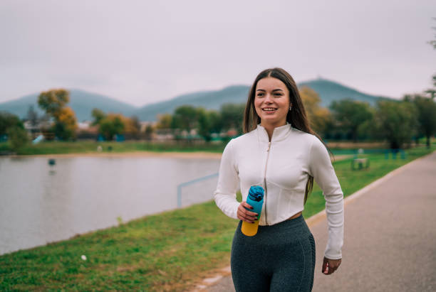 istock A young woman runs on the track in the morning hours, dressed in athletic gear that reflects her energy and dedication. 2182749607