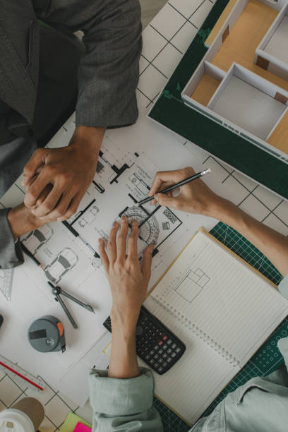 istock an architect and his assistant are brainstorming and examining the blueprints, two engineers are discussing a construction plan to make the structure stronger, draft, meeting, teamwork 2182755061