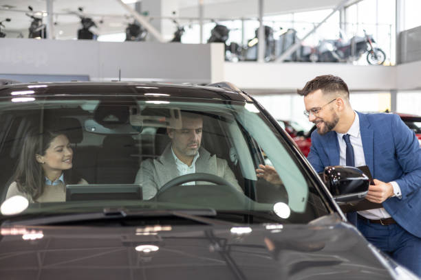 istock Couple testing a new car with salesman on the side 2182757436