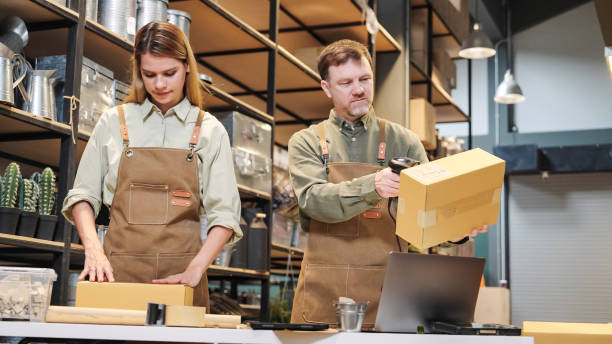 istock A small business warehouse  worker owner  using Barcode Scanner of cardboard packages box reading labels  before delivery at warehouse and  checking inventory and  packing new orders online for customer eco friendly brown paper wrapped with environmental 2182765335