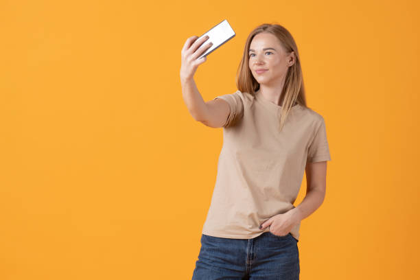 istock Young Woman Taking a Selfie on a Yellow Background 2182770408