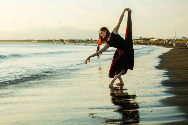 istock Beautiful young lady dancing in sunset beach 2182774240