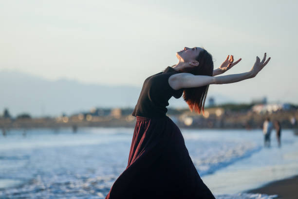 istock Beautiful young lady dancing in sunset beach 2182774369