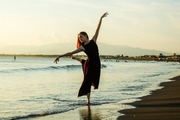 istock Beautiful young lady dancing in sunset beach 2182774414