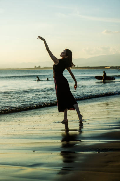 istock Beautiful young lady dancing in sunset beach 2182774615